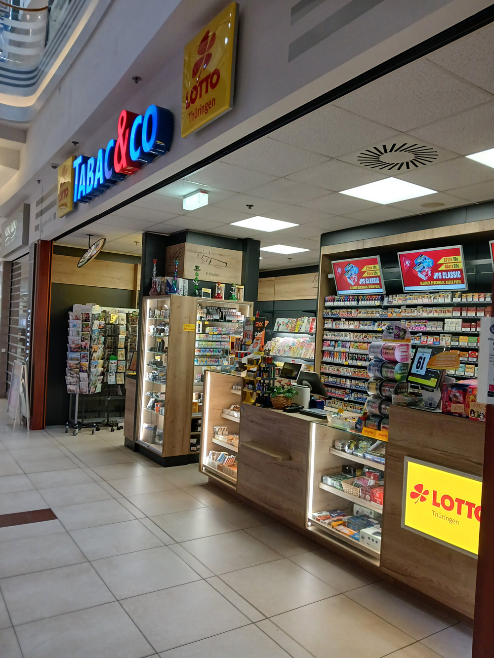 Tabakladen mit Regalen voller bunter Waren und Lottoschildern im Einkaufszentrum